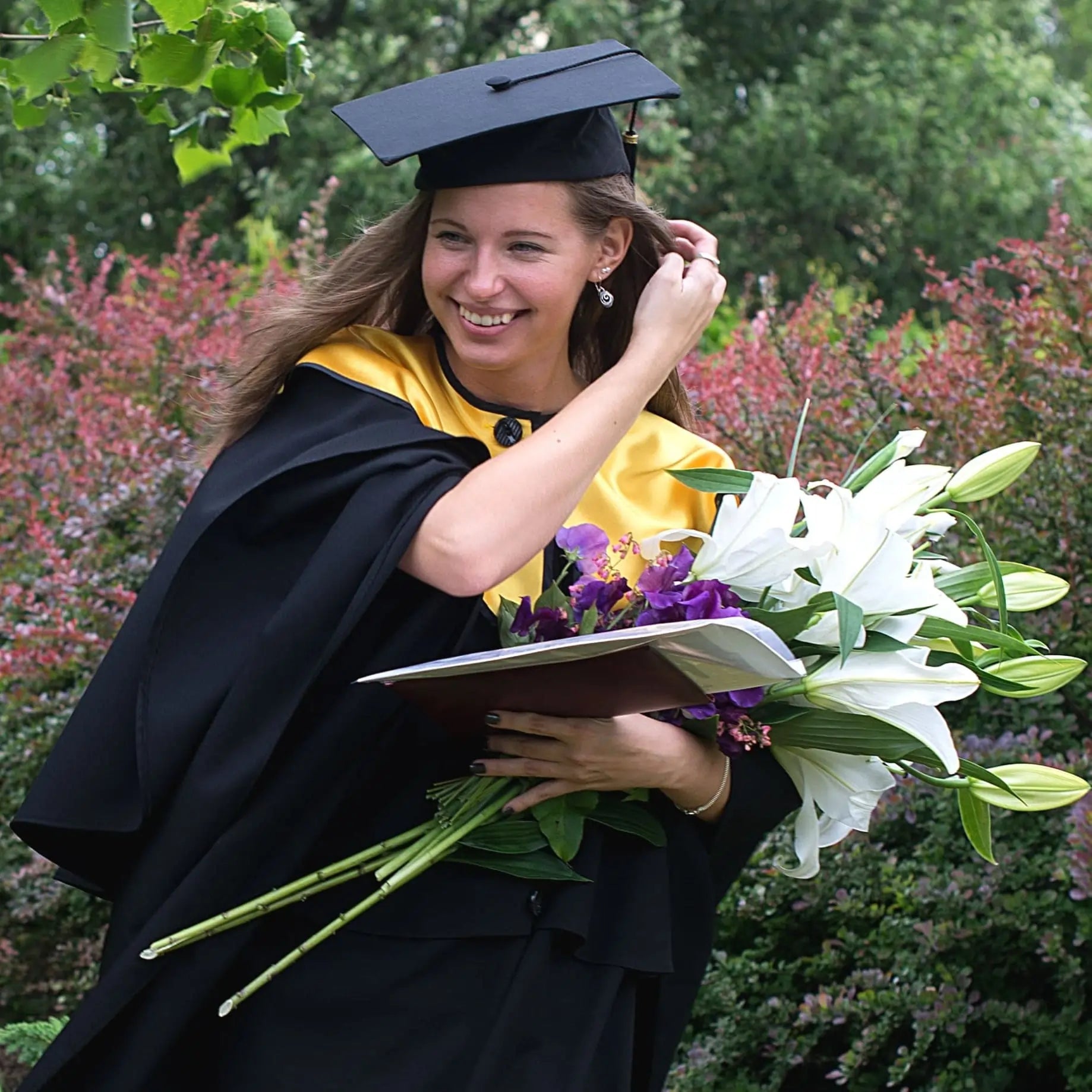 Graduation photo of woman with flowers.