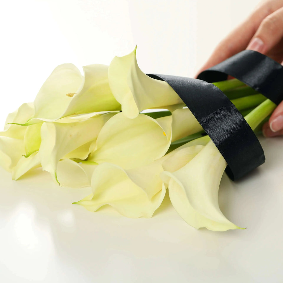 Calla lilies tied with black ribbon
